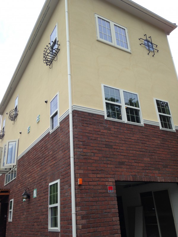 ブリックと塗り壁が印象的な3F建ての家